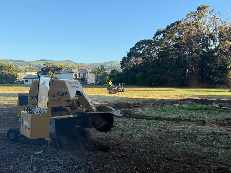 Stump grinder on cleared ground at the airfield, with the hills behind Apollo Bay in the distance