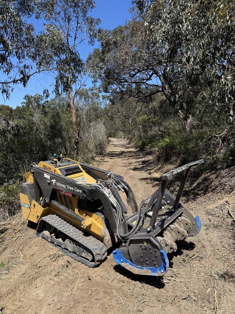 Tracked loader fitted with a mulching head on a freshly cleared bush track
